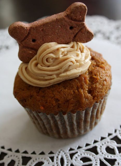 there is a cupcake with icing and a dog head on top of it