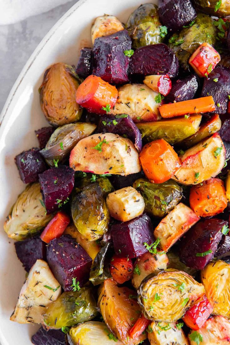 a white bowl filled with roasted vegetables on top of a table