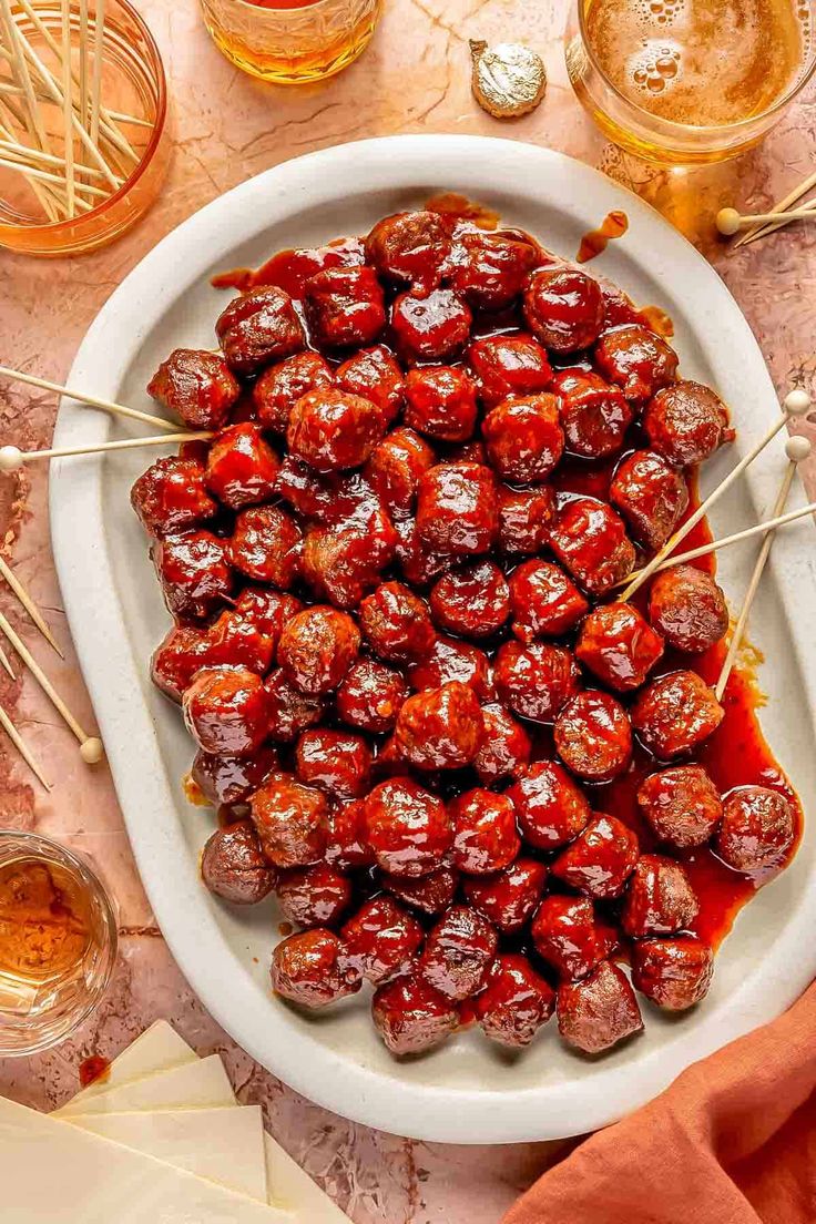 meatballs on skewers with ketchup and mustard in a white dish