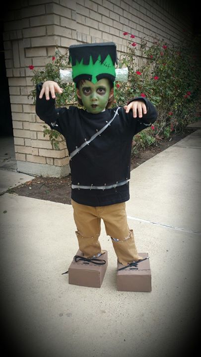 a young boy wearing a costume made to look like he is holding his head in the air