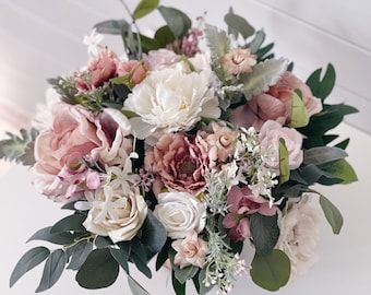 a vase filled with lots of pink and white flowers