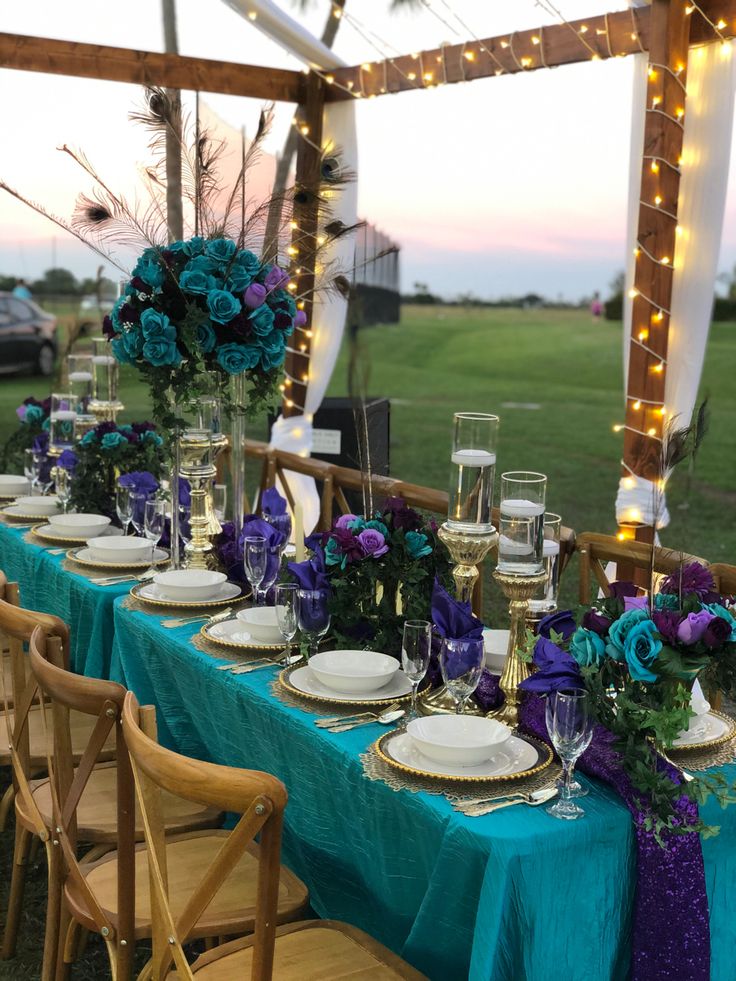 a table set up with blue and purple flowers