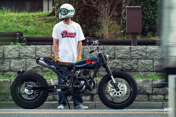 a man standing next to a parked motorcycle