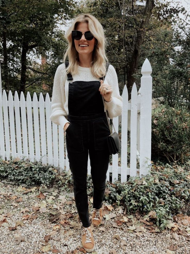 girl taking a picture in front of a white fence Styling Dungarees Winter, Mostly Black Outfit, Styling Black Overalls, What To Wear With Black Overalls, Black Dungarees Outfit Winter, How To Style Black Overalls, Black Overalls Outfit Winter, Black Overall Outfit, Black Overalls Outfit Fall