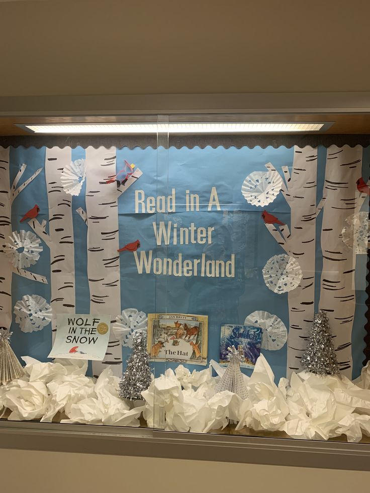 a bulletin board with trees and snowmen in the background, surrounded by white tissue