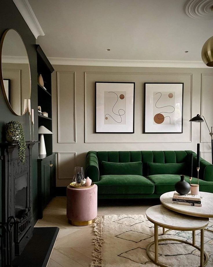 a living room with green couches and pictures on the wall