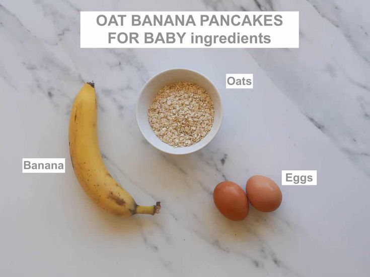 bananas, eggs and oats in a bowl on a marble counter top with the words oat banana pancakes for baby ingredients