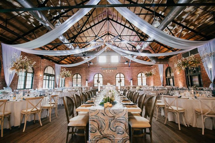 an indoor wedding venue with tables and chairs