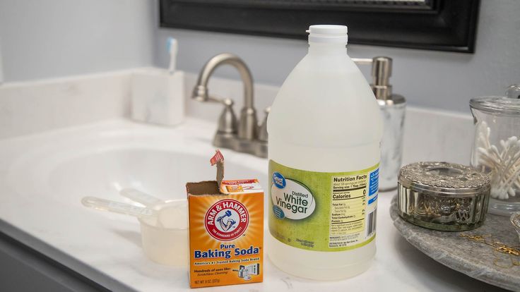 a bottle of baking soda sitting on top of a bathroom counter next to a soap bar