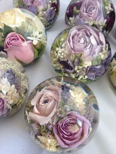 several glass vases filled with flowers on top of a white tablecloth covered table