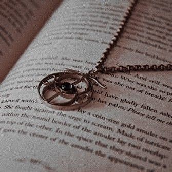 an open book with a necklace on it