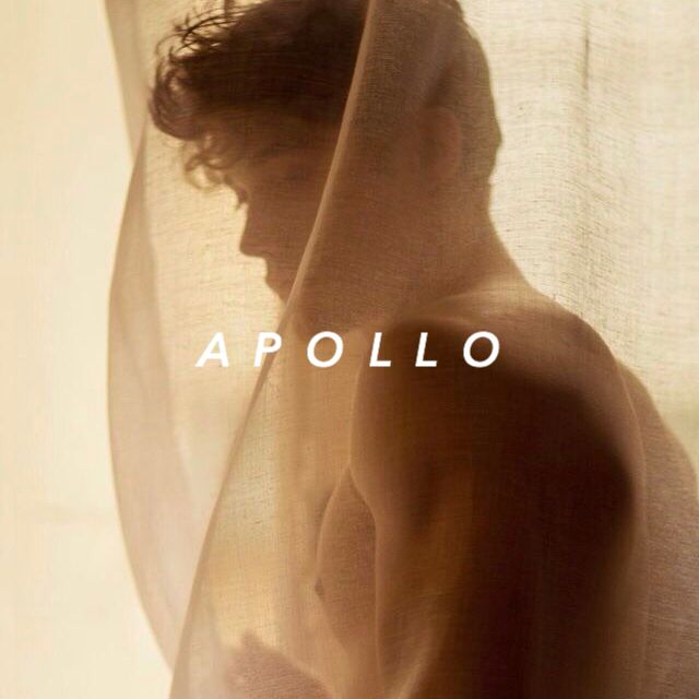 a man standing in front of a curtain with the words apollo on it