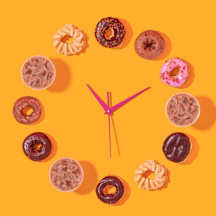 a clock made out of doughnuts on an orange background