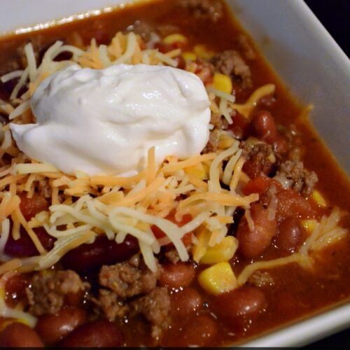 a white bowl filled with chili and cheese