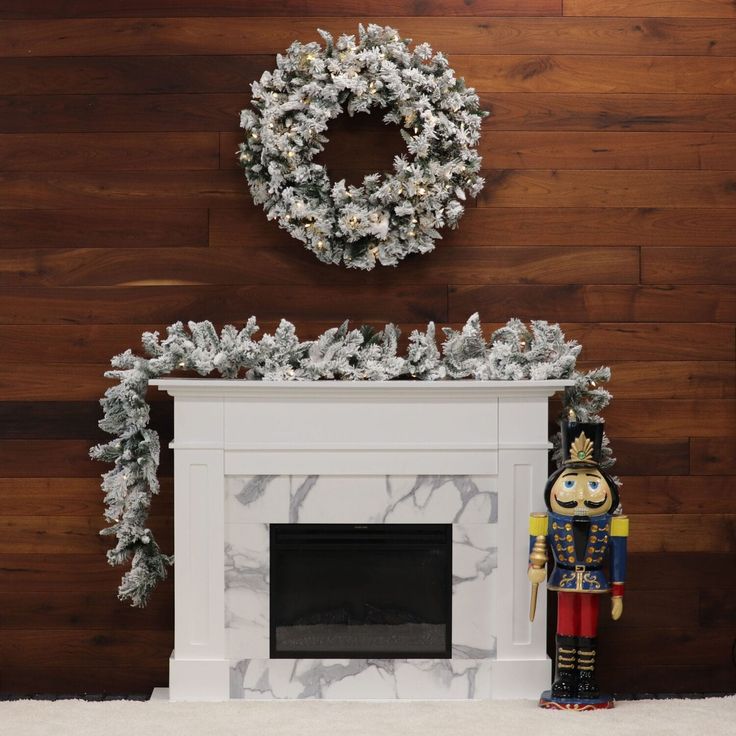 a fireplace with a wreath on top and a nutcracker statue next to it