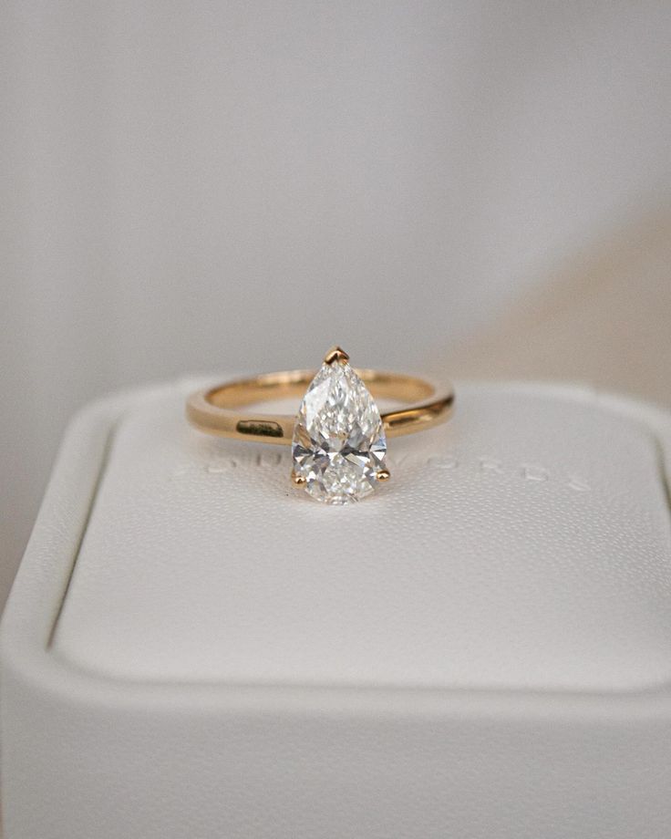 a diamond ring sitting on top of a white box