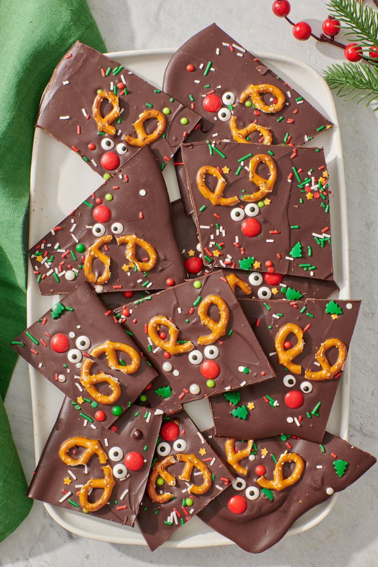 christmas pretzels on a plate with chocolate and sprinkles for decoration