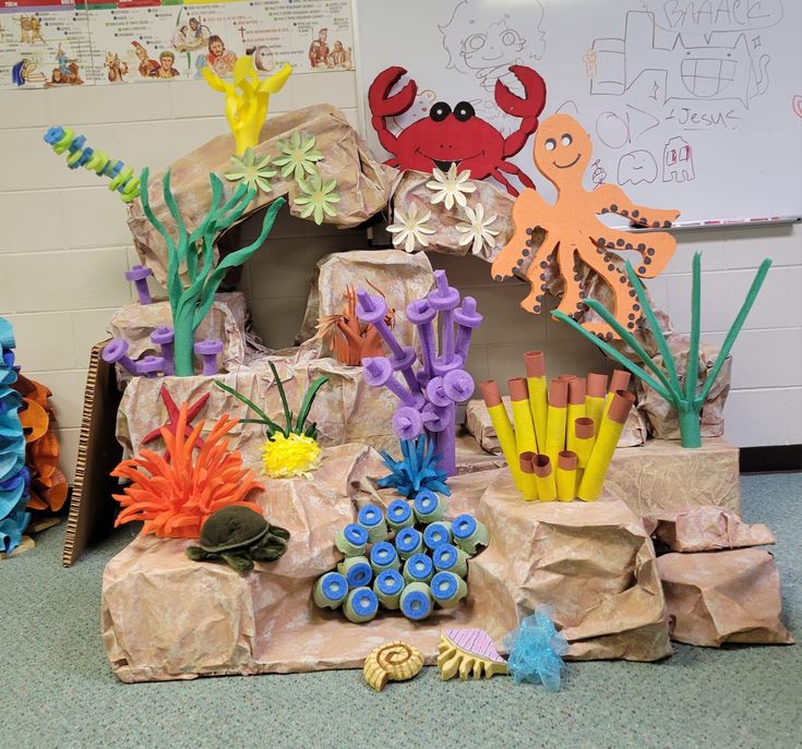 an ocean scene made out of paper and crafting supplies with sea animals on the rocks