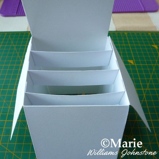 an open white box sitting on top of a cutting board next to a green mat