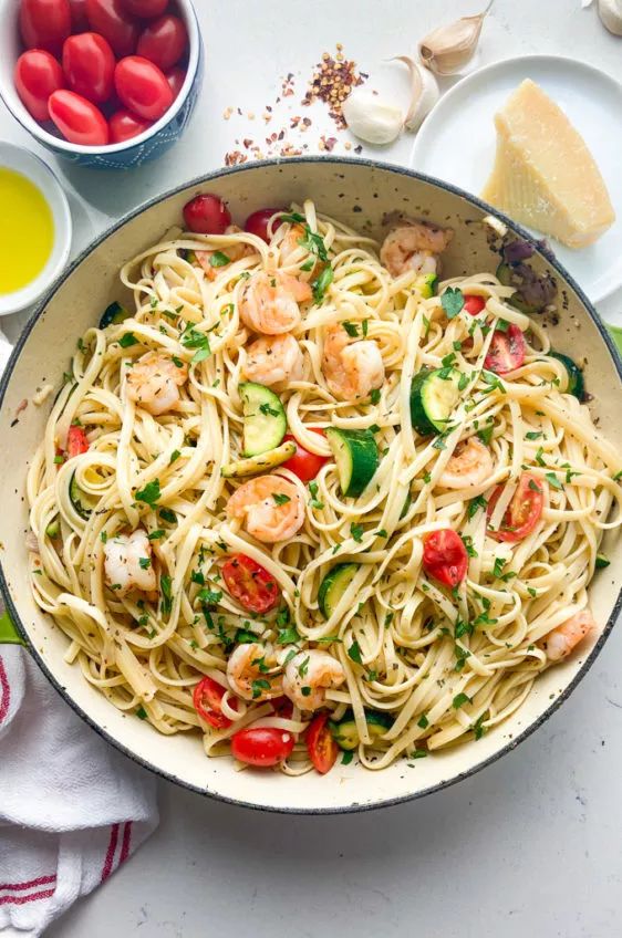 a pan filled with pasta and shrimp on top of a table