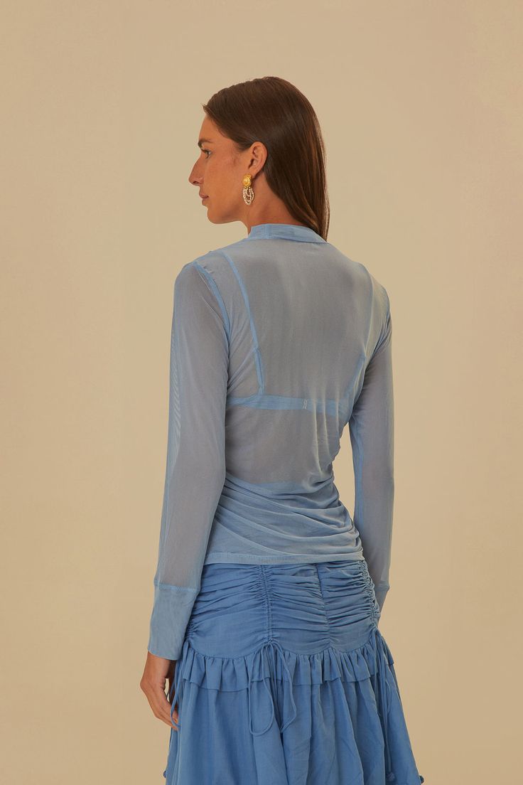 Indulge in a touch of elegance with our Blue Tulle Long Sleeved Blouse. Featuring a high neckline and long sleeves, this top adds a soft, playful sophistication to any outfit. Embrace a classic look with a modern twist with the clasp closure and solid print. Perfect for any occasion!Composition 93% POLYESTER 7% ELASTANE + 93% VISCOSE 7% ELASTANECare Instructions MACHINE WASH SEPARATELY, DO NOT BLEACH, DO NOT TUMBLE DRY, LINE DRYING, IRON AT LOW HEAT, DRY CLEAN WITH ANY SOLVENT EXCEPT TRICHLOROETHYLENESize and Fit Inches XXS XS S M L XL Bust 25 27 29 31 34 37 1/4 Waist 23 25 27 29 32 1/8 35 2/7 Length 20 1/3 21 21 1/2 22 22 2/3 23 1/4 Hip 26 28 30 32 38 1/4 38 1/4 Line Drying, Blue Tulle, Farm Rio, Blue Blouse, High Neckline, Classic Looks, Short Tops, New Arrivals, Bleach