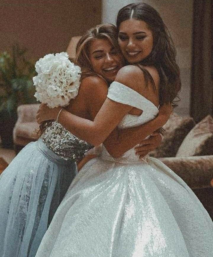 two girls in dresses hugging each other