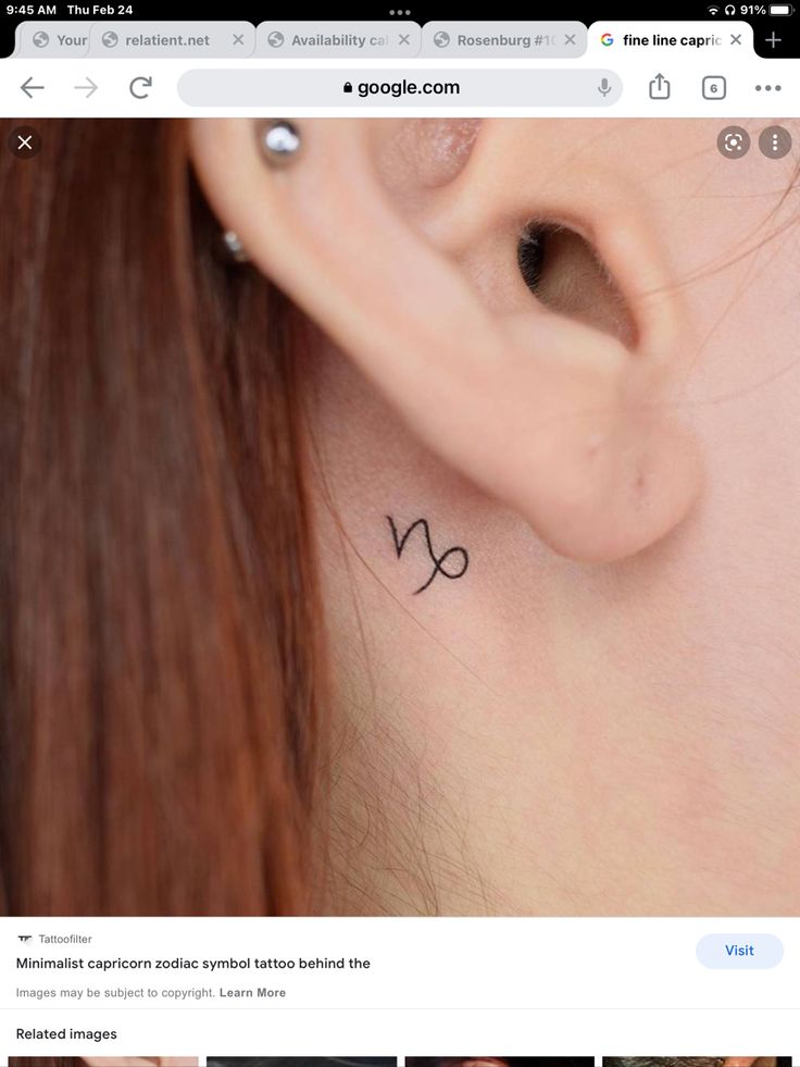 a woman's ear with the zodiac sign on it