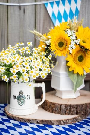 two vases filled with yellow and white flowers on top of a blue and white checkered table cloth