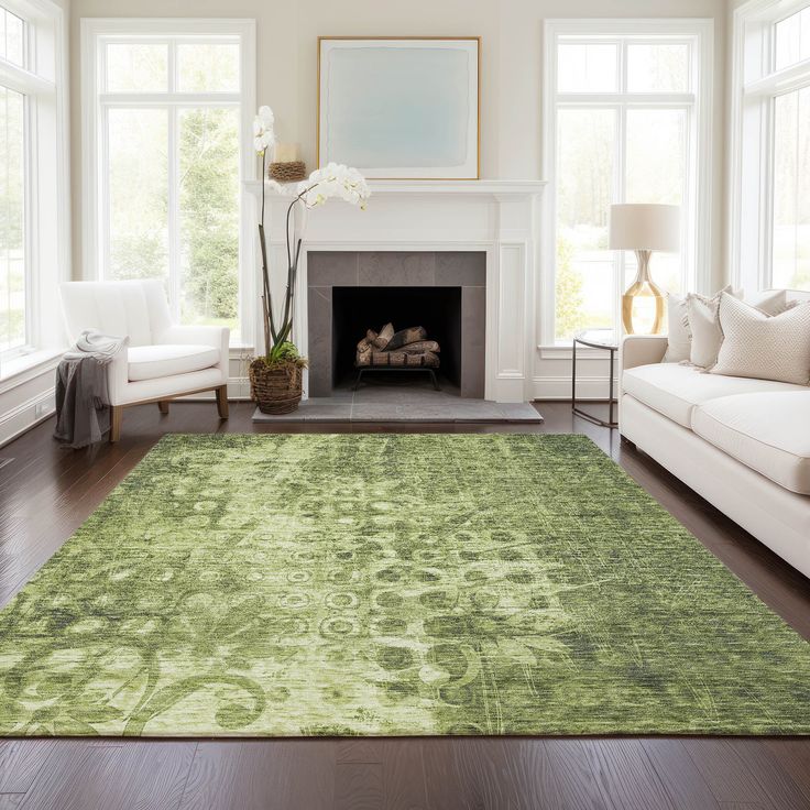 a living room filled with furniture and a green rug on top of a hard wood floor