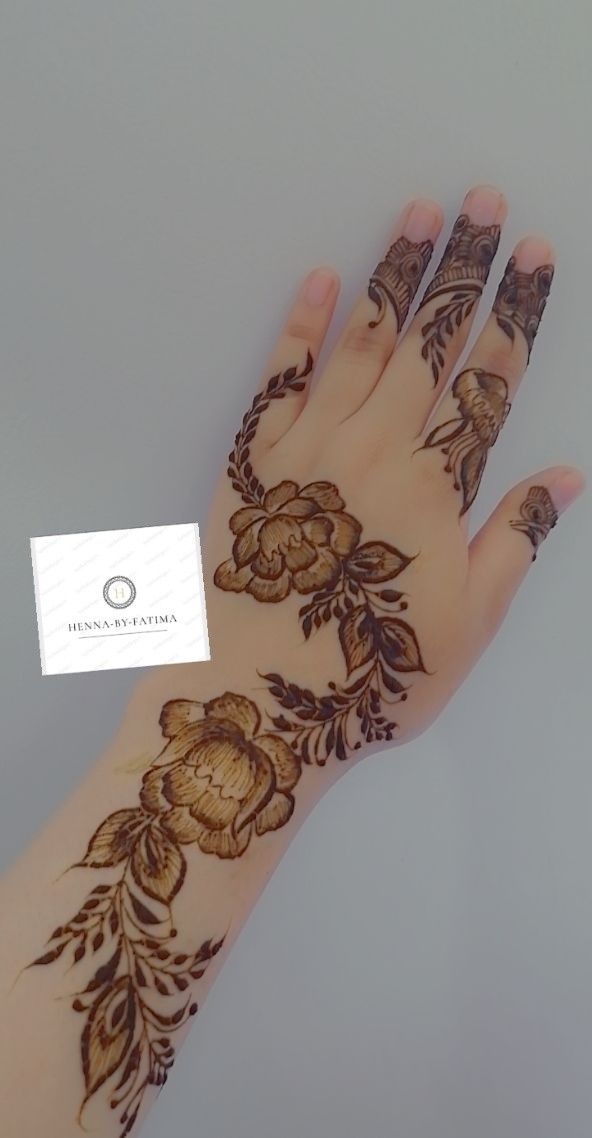 a woman's hand with henna tattoos on it