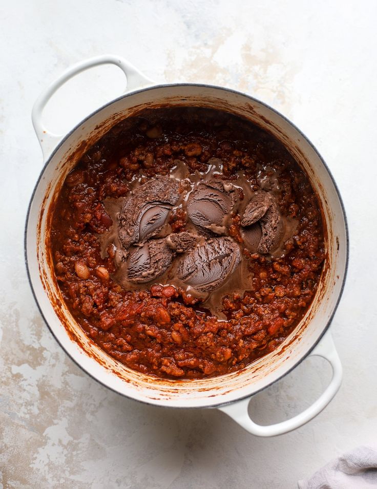 a pot filled with chili and beans on top of a table