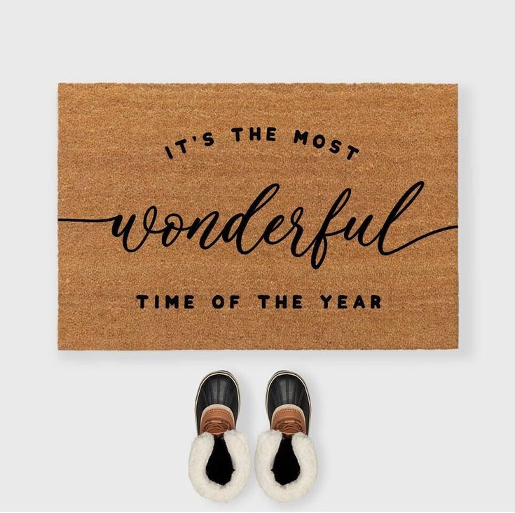 a door mat that says it's the most wonderful time of the year with two pairs of shoes next to it