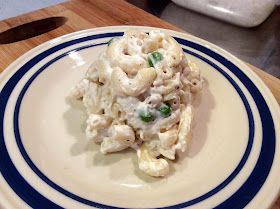 a white plate topped with macaroni and cheese on top of a wooden table