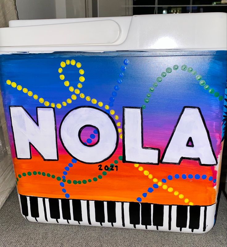 a cooler with the word nola painted on it