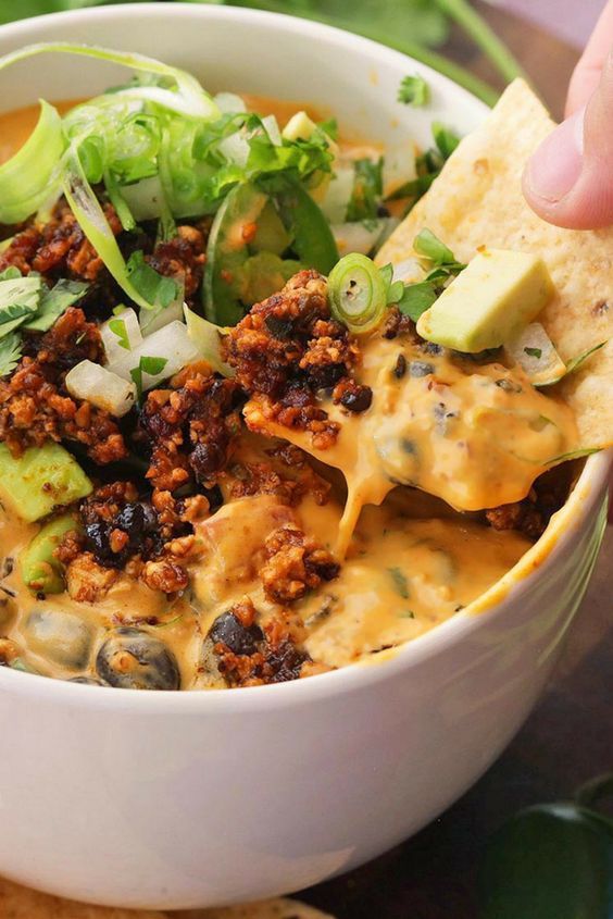 a close up of a bowl of food with the words fully loaded vegan quesa dip