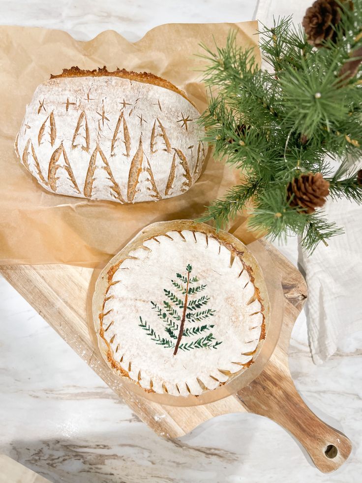 two pieces of bread sitting on top of a cutting board next to a pine tree