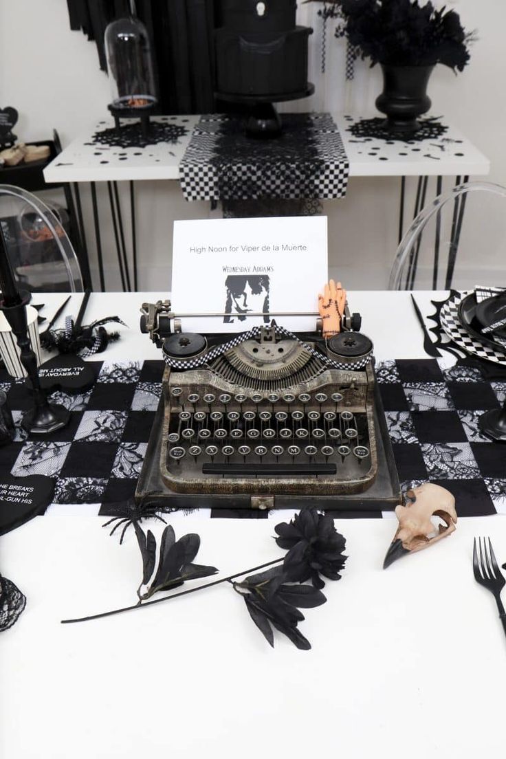 an old fashioned typewriter sitting on top of a table covered in black and white decorations