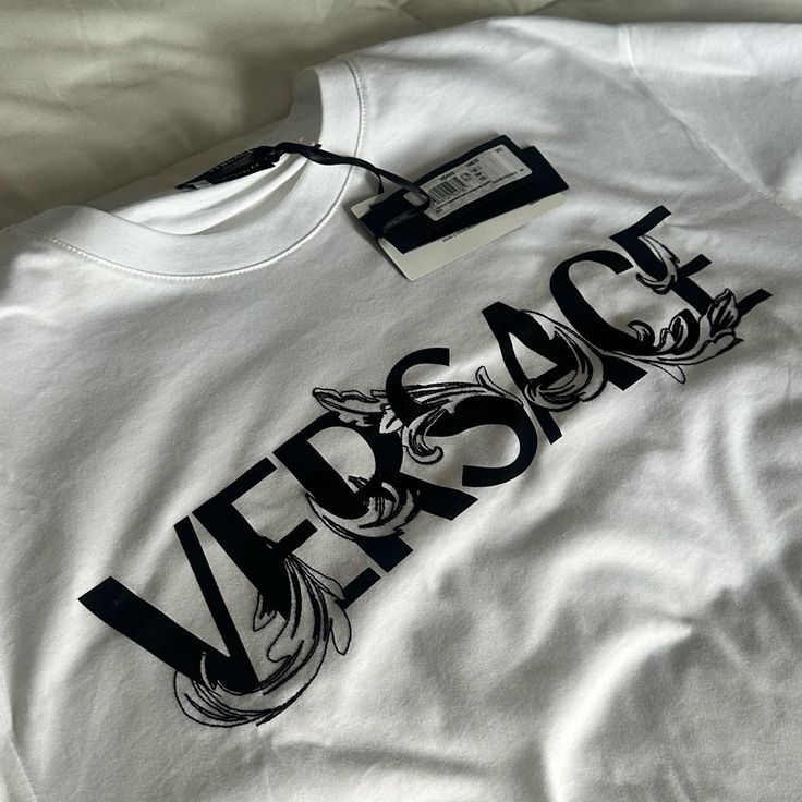 Never Used. Selling Due To Unwanted Gift. Details: Versace T-Shirt With Two-Tone Barocco Logo Print On Chest L Man Size, Soft Cotton, Mitchel Fit Crew Neckline Short Sleeves Cotton Machine Wash Made In Italy Versace Tshirt Men, Luxury Monogram Print Streetwear Top, Luxury Logo Print Crew Neck Top, Luxury Crew Neck Top With Logo Print, Luxury Monogram Print Top For Streetwear, White Monogram Print Graphic Tee, Elegant Crew Neck Top With Graphic Print, White Monogram Print Streetwear Top, Luxury Crew Neck Top For Streetwear