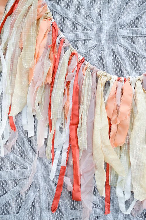 an assortment of different colored ribbons hanging from a string on a quilted table cloth