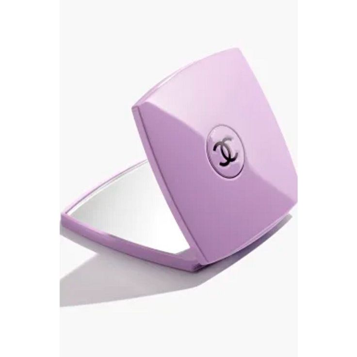 a pink compact mirror sitting on top of a white surface