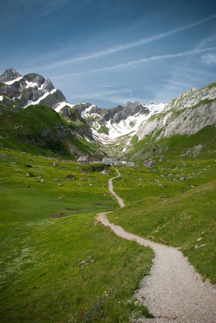 a path in the middle of a green valley