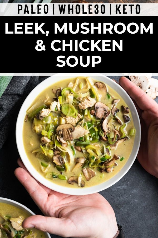 two hands holding bowls of soup with mushrooms and green onions in it, on top of a black surface