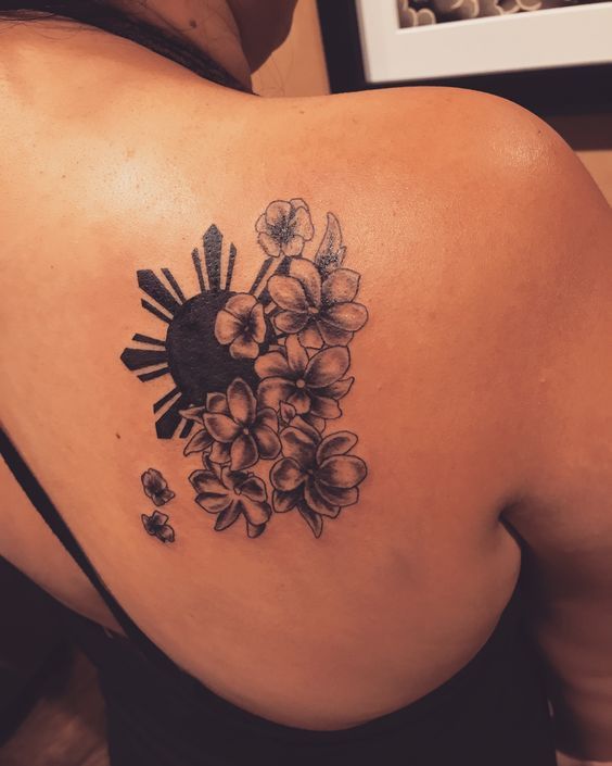 a woman's back tattoo with flowers on it