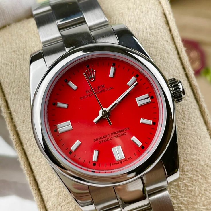 This Rolex Oyster Perpetual 36mm is a vibrant and modern expression of Rolex's timeless design. Its bold red dial instantly catches the eye, strikingly contrasting the Oystersteel case and bracelet. The white gold hour markers, filled with Chromalight, ensure legibility in any lighting. Powered by the Calibre 3230 movement, this watch boasts exceptional precision and a 70-hour power reserve, meeting Rolex's stringent Superlative Chronometer standards. This Oyster Perpetual with its vivid red dia Classic Red Watch With Metal Dial, Red Automatic Watches With Round Dial, Red Automatic Watch With Round Dial, Red Watch With Date Indicator And Round Dial, Luxury Red Watches With Date Indicator, Luxury Red Watch With Date Indicator, Modern Red Watches With Metal Dial, Modern Red Watches With Subdials, Classic Red Watch As A Gift