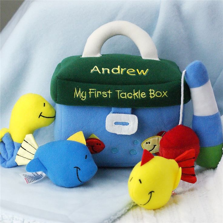 an assortment of stuffed animals sitting on top of a white blanket next to a blue bag