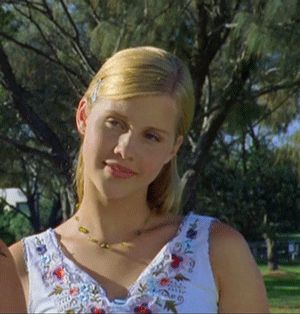 a woman in a white top is holding a frisbee