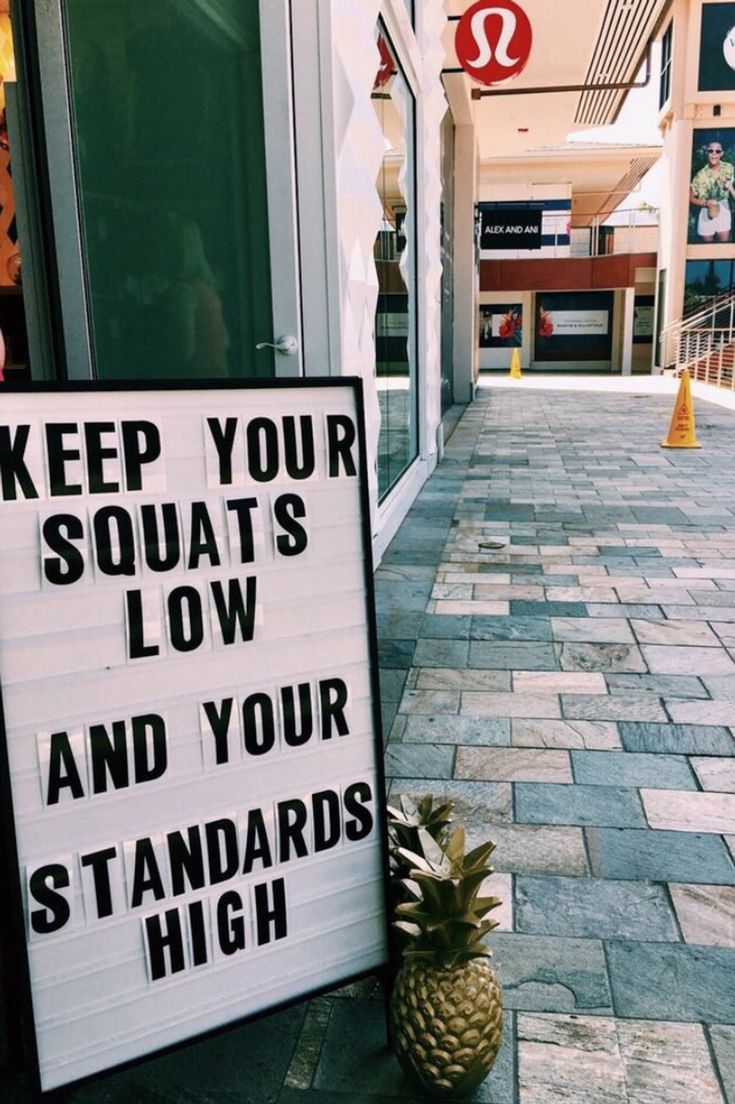 a sign on the sidewalk that says keep your squats low and your standards high