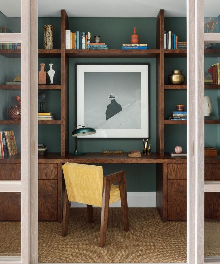 a desk with a chair and bookshelves in front of it, next to a book shelf