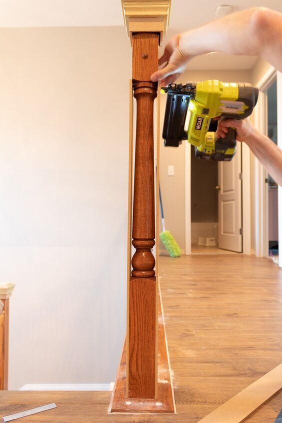 a person using a power drill to attach a clock on a post in a house