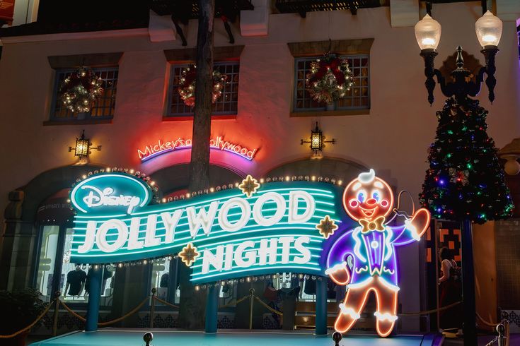 the entrance to hollywood nights lit up at night with christmas lights and decorations on display